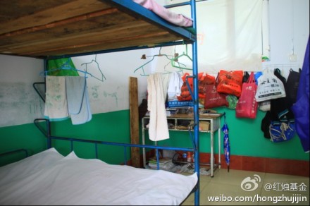 学生宿舍没有柜子，孩子们的衣物只能放在塑料袋里挂在墙上